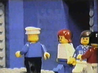 Foto: Verschiedene bunte Lego-Figuren versammeln sich in einem grau-blauen Gang.