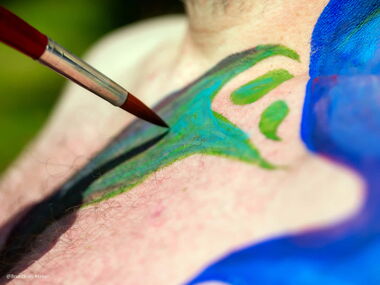 Mimi malt eine Figur auf meinen Oberkörper, die einem Engel gleicht.