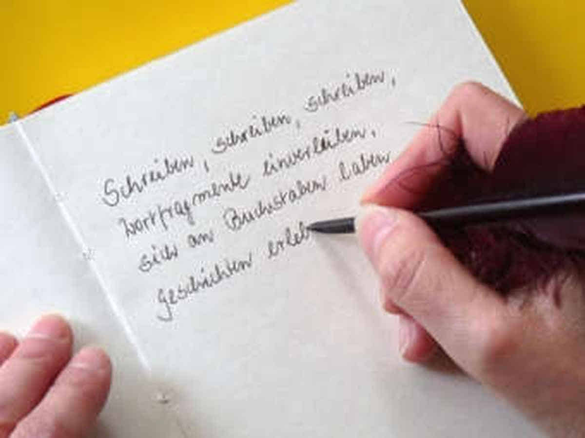 Foto: Hier schreibe ich mit Feder und Tinte einen Text in ein leeres Buch.