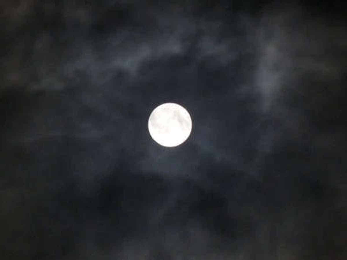 Foto: Um den klaren Vollmond ranken sich dunkle Wolkenhaufen.